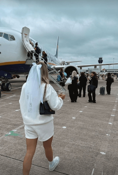 a woman with a veil on her head is walking towards an airplane