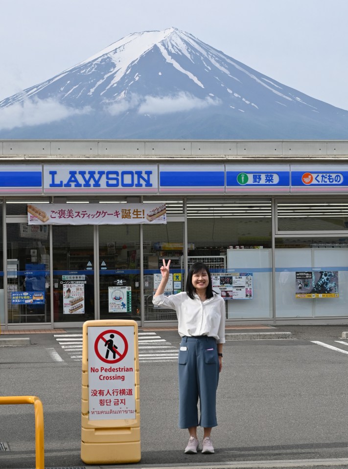 A person poses for a photograph hours before the installation of a barrier across the street