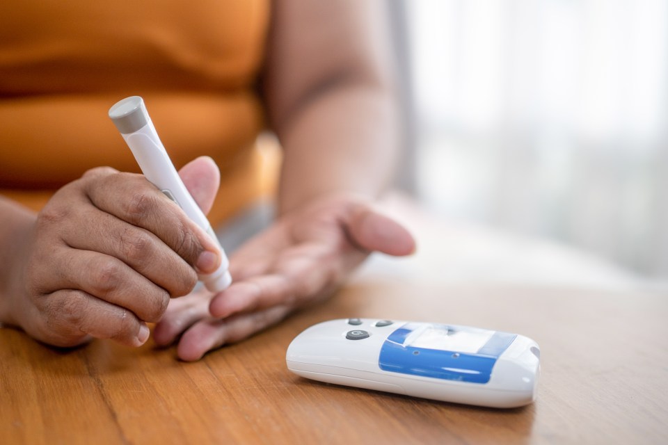 Blood sugar finger prick testing with portable glucometer.