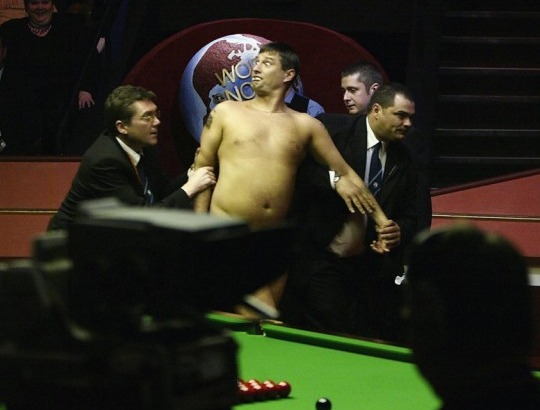 SHEFFIELD, ENGLAND - MAY 3: A streaker, Mark Roberts, is led out of the arena during the Embassy World Snooker Final between Ronnie O'Sullivan and Graeme Dott at the Crucible Theatre on May 3, 2004 in Sheffield, England. (Photo by Gary M.Prior/Getty Images)