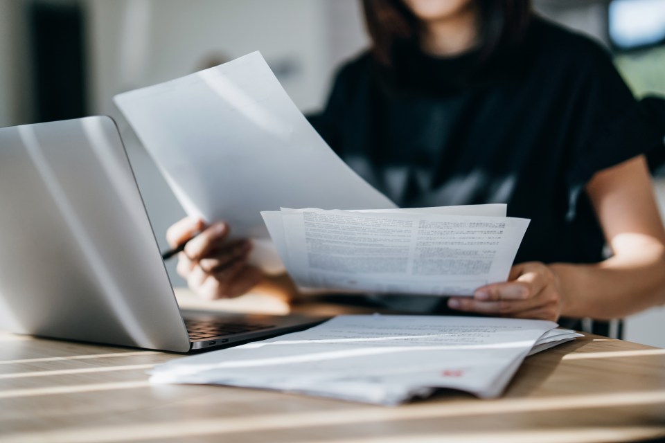 a woman is holding a piece of paper that says ' a ' on it