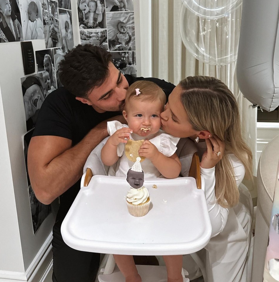 a baby in a high chair with a cupcake with a face on it