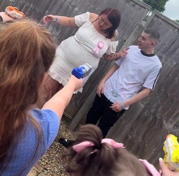 As they shot the water at the pair, it came out pink - showing they were having a third daughter