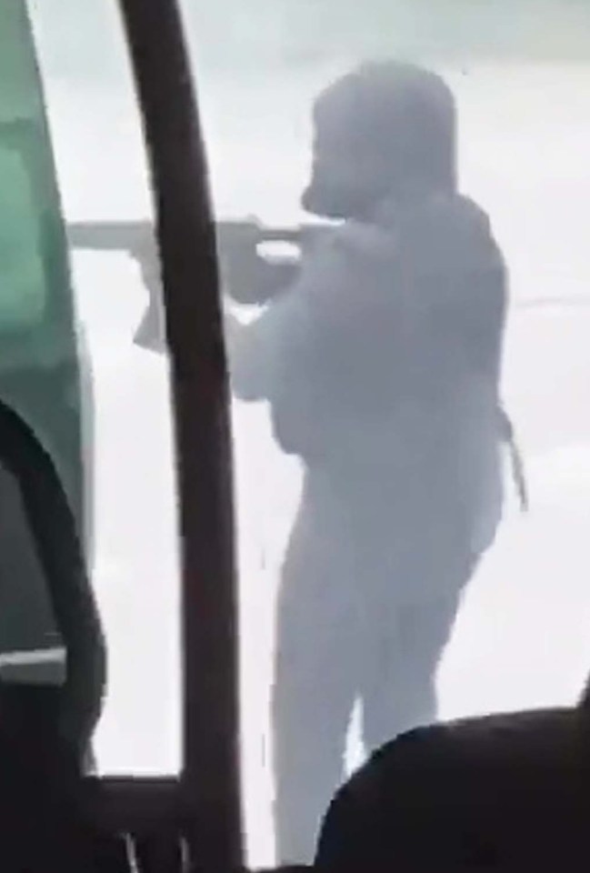 One of the shooters brandishes a huge rifle at the scene of the attack