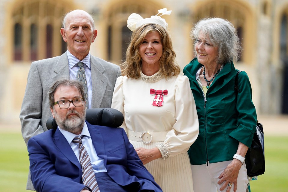 Kate with her parents and late husband Derek as she’s awarded with an MBE