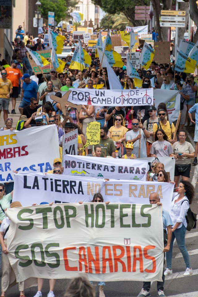 Protesters in the Canary Islands hold a sign that reads 'Stop Hotels'