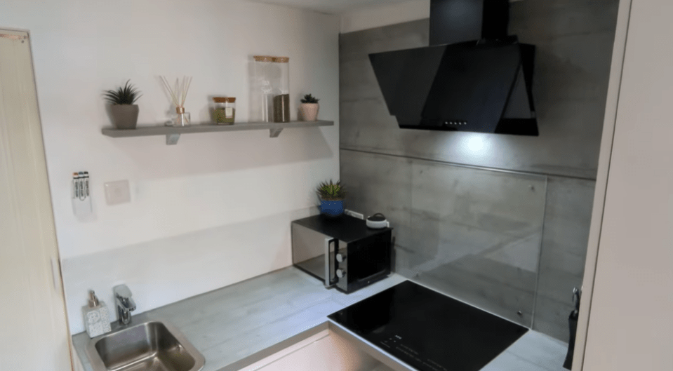 The snug kitchen area, with electric stove and microwave