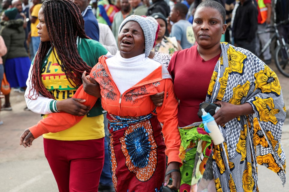 So far 13 people have been killed and at least 39 remain unaccounted for - this image shows the grieving families of those involved