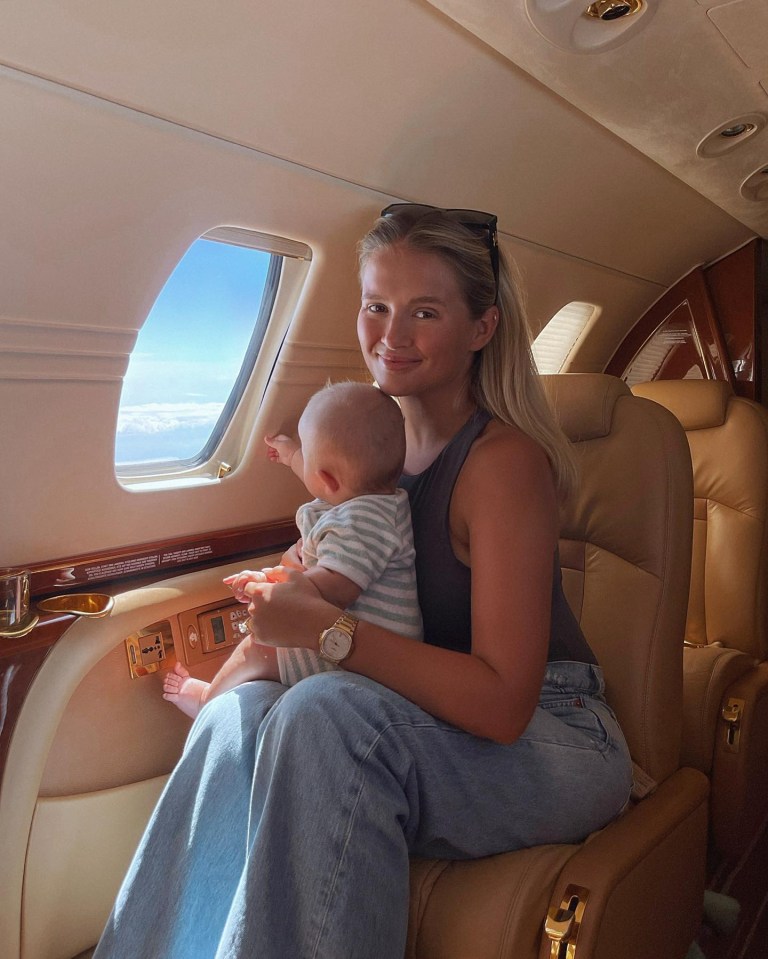 a woman holds a baby in her lap on a plane