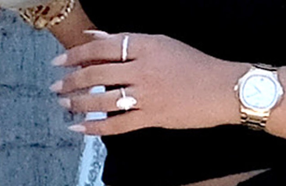 a woman wearing a watch and a ring on her left hand