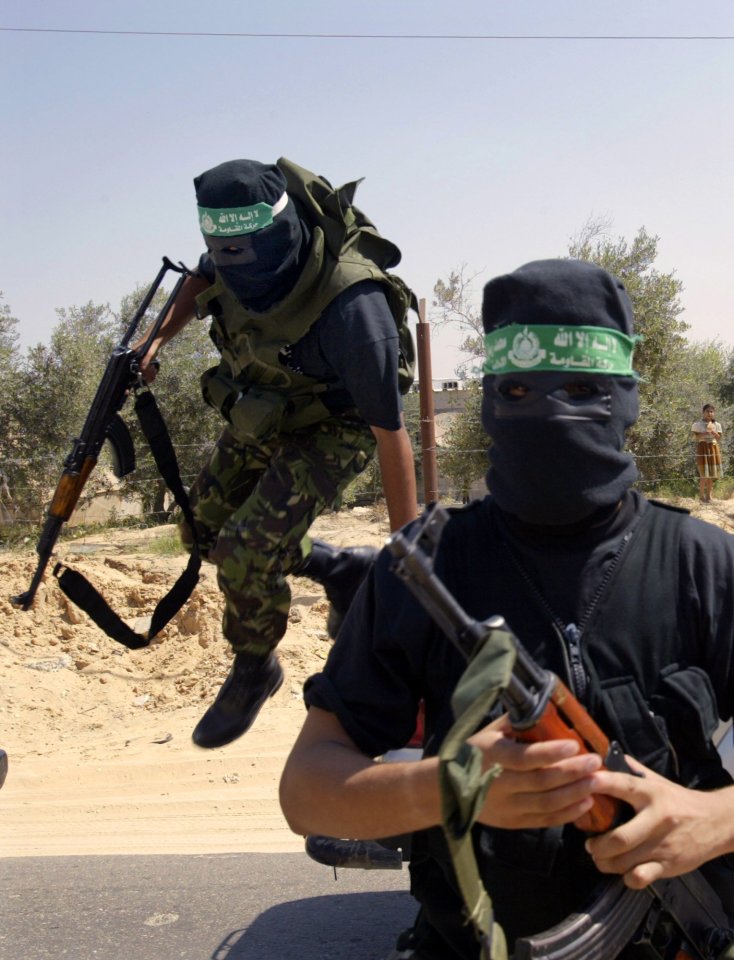 Hamas fighters jump from the back of a pickup truck outside Rafah hospital