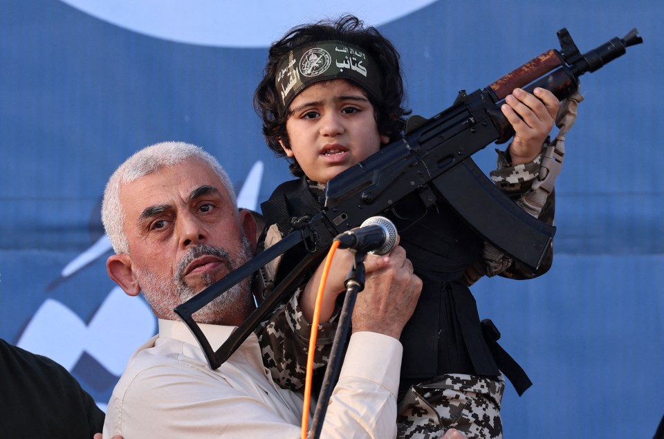 Hamas leader Yahya Sinwar holds the child of an Al-Qassam Brigades fighter