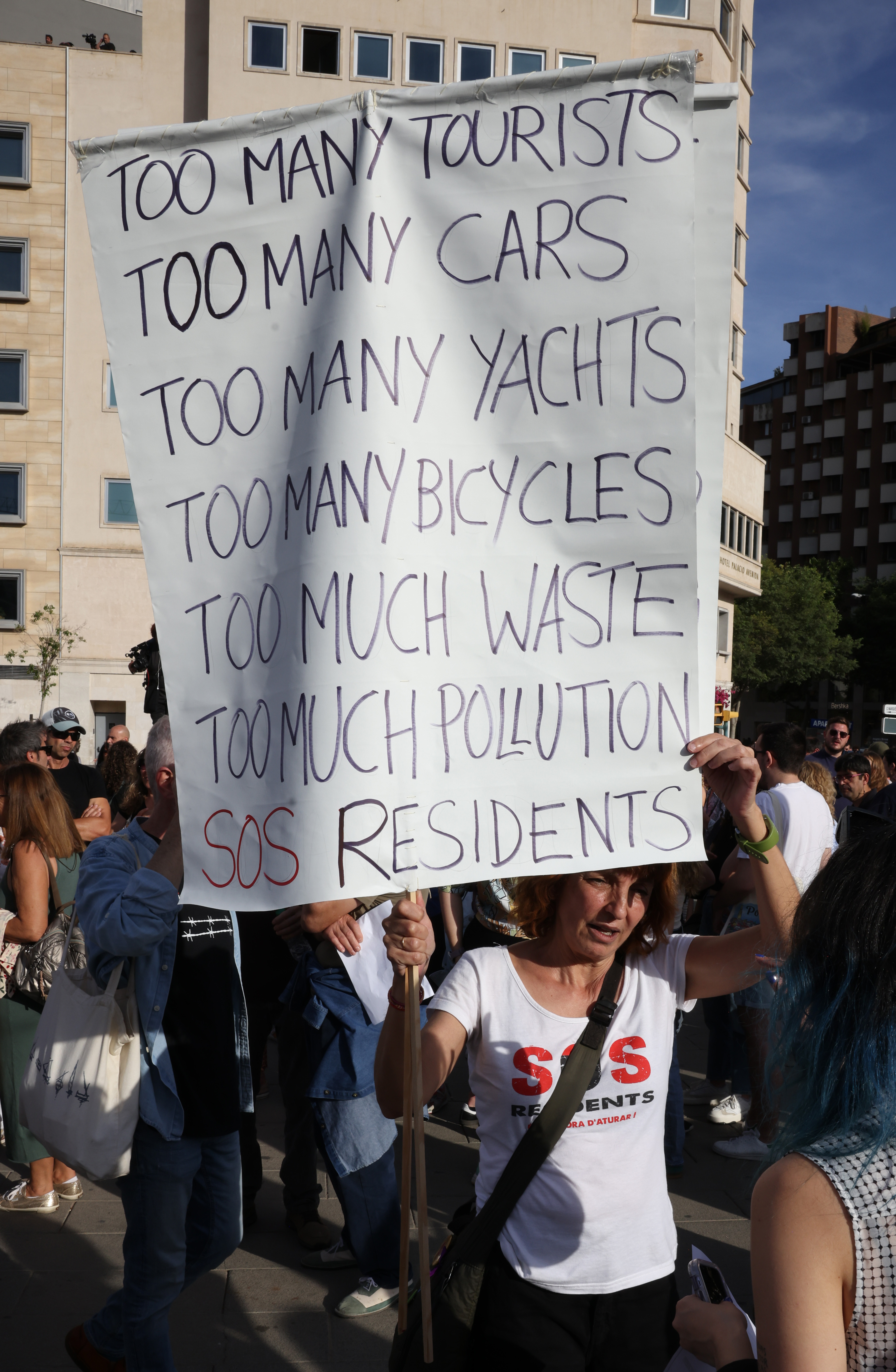 One protester holds a placard which reads: 'SOS residents'