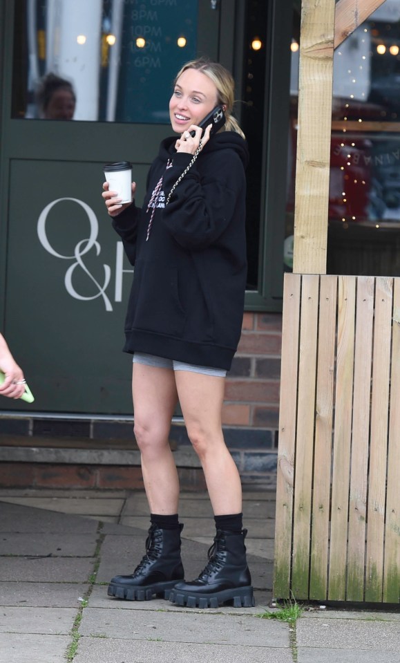 She wore a huge black hoodie to cover her bump over a pair of shorts