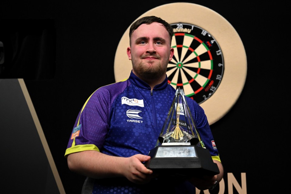 LONDON, ENGLAND - MAY 23: Luke Littler of England celebrates with the trophy after winning the Final match against Luke Humphries of England at the 2024 BetMGM Premier League Darts Play-Offs at The O2 Arena on May 23, 2024 in London, England. (Photo by Justin Setterfield/Getty Images)