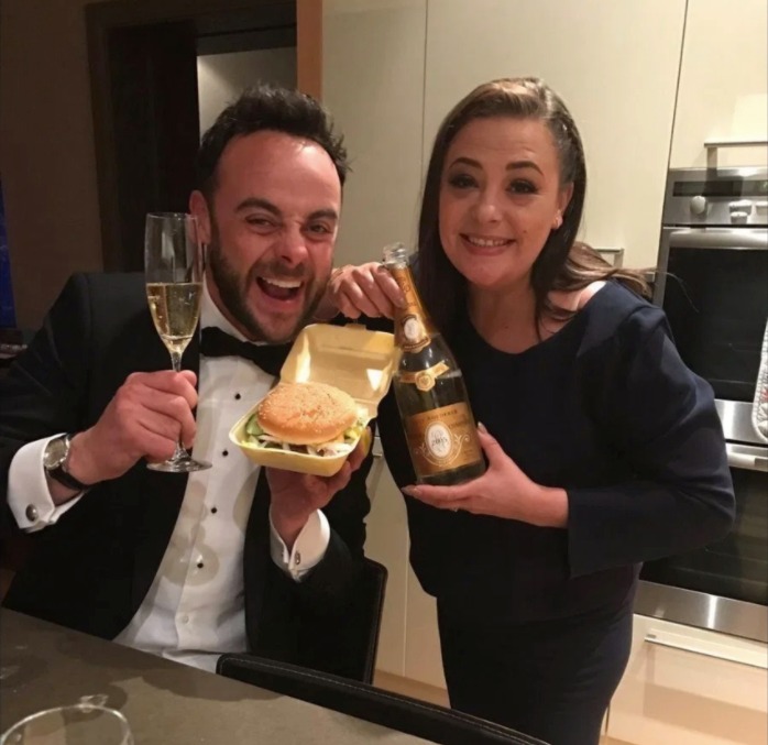 Ant and Lisa celebrating in the kitchen with Champagne and a burger after an awards win