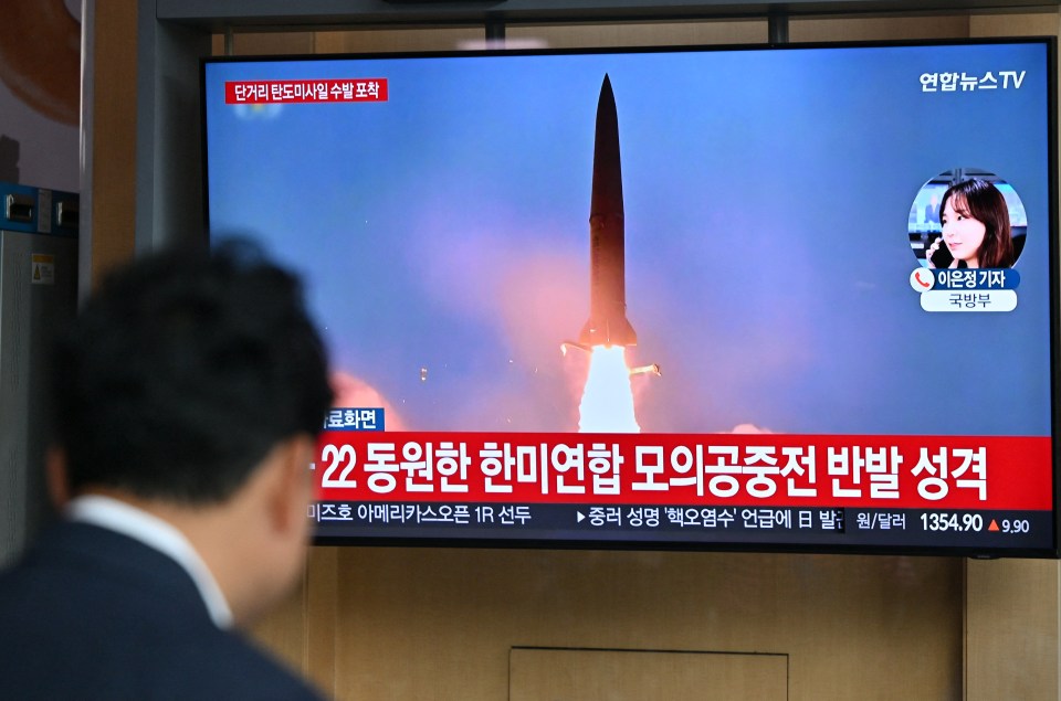 A man in South Korea watches a TV screen showing a news broadcast of a North Korean missile test,