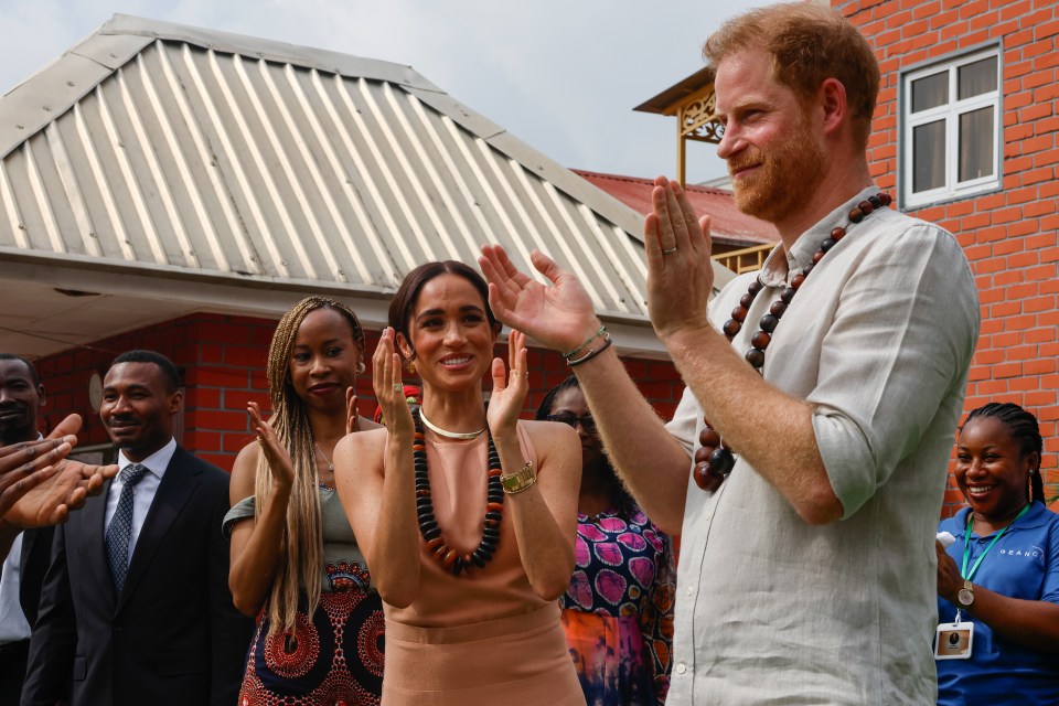 Harry and Meghan react during a welcome ceremony as they visit the Lightway Academy