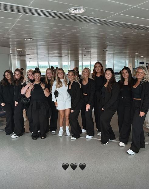 a group of women wearing all black posing for a picture