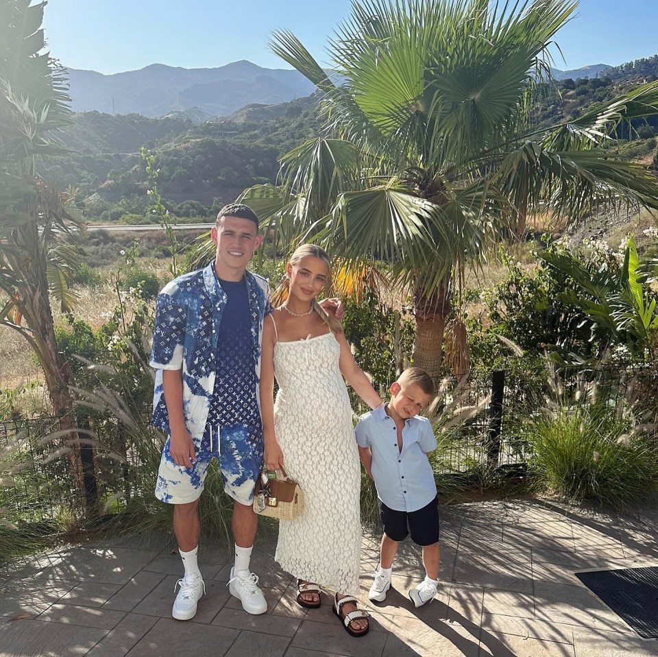 a family posing for a picture in front of a palm tree