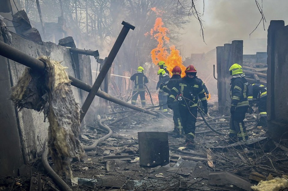 Rescuers pictured extinguishing a fire at the site of a missile attack in Odesa, Ukraine