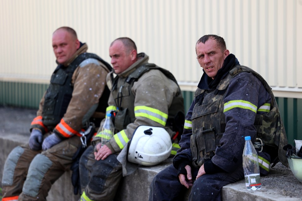 Exhausted firemen pause for a drink of water while on-scene