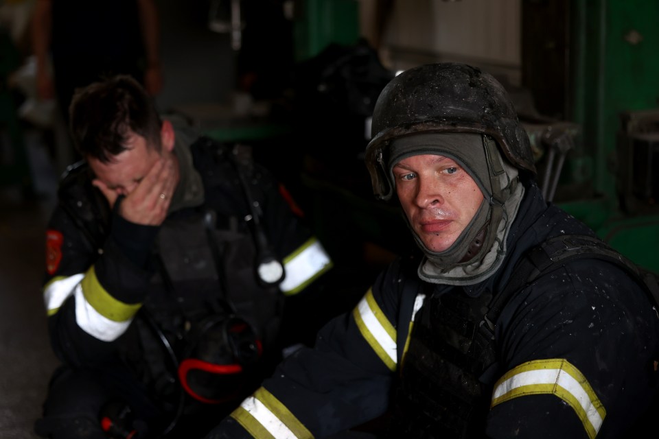 Firemen appear exhausted after probing the charred remains of the publishing house