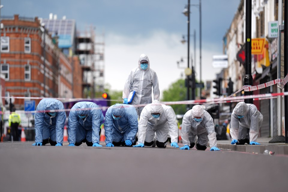 Police forensic officers on Kingsland High Street, Hackney, east London, near to the scene of a shooting