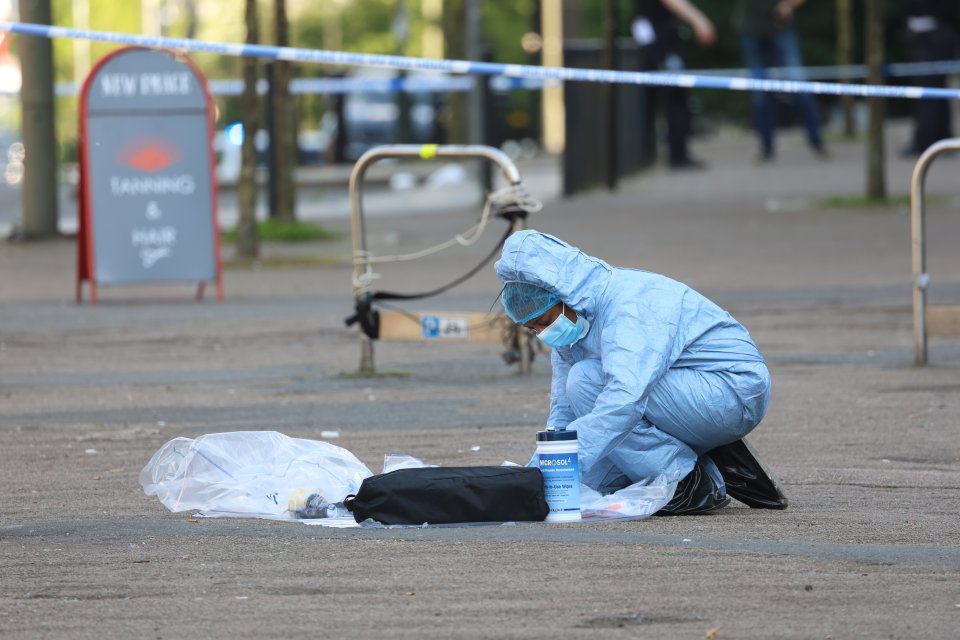 A forensic officer collecting evidence within the cordon