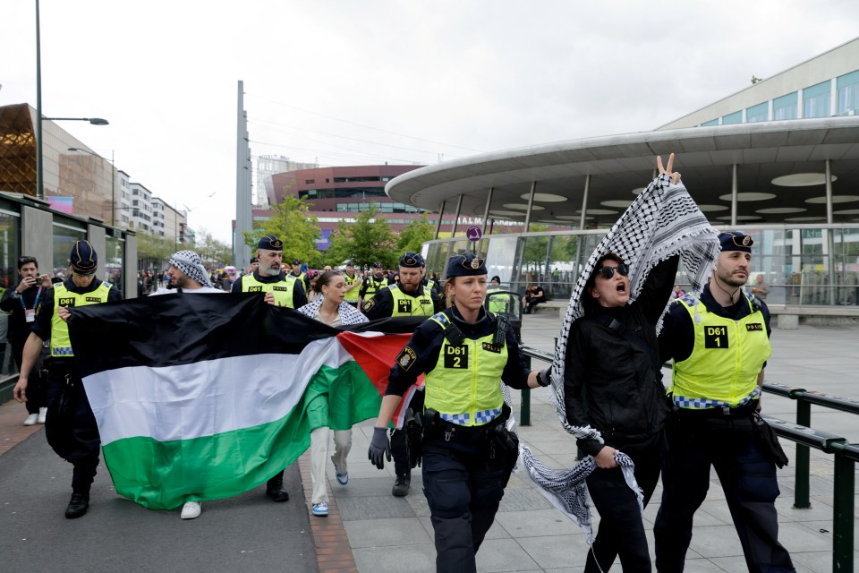 Police officers escort demonstrators with a Palestinian flag on Saturday