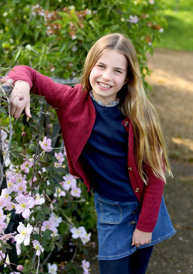 Princess Charlotte poses in a charming photo taken to mark her ninth birthday - the purple blooms — Clematis Elizabeth — are named in honour of the late Queen