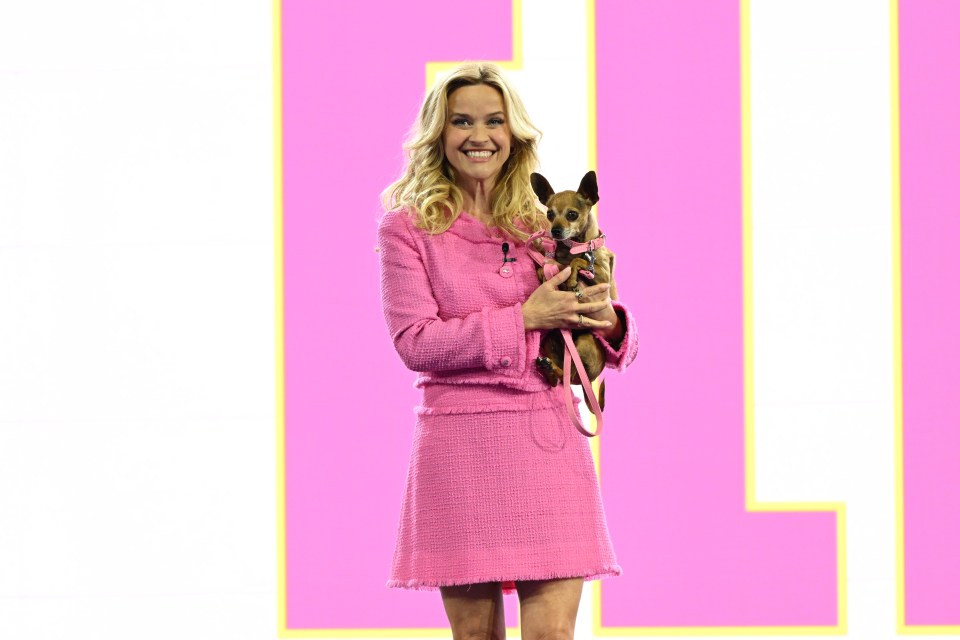 Reese wore a pink skirt suit and carried a chihuahua