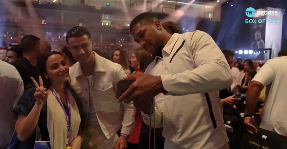 Anthony Joshua taking a picture for a fan with Cristiano Ronaldo