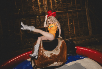 She also rides a mechanical bull in the promo