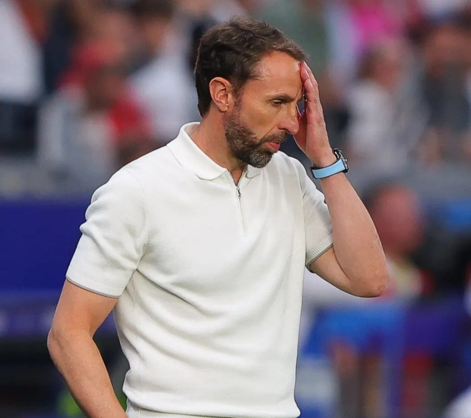 a man wearing a white shirt and a blue watch holds his head