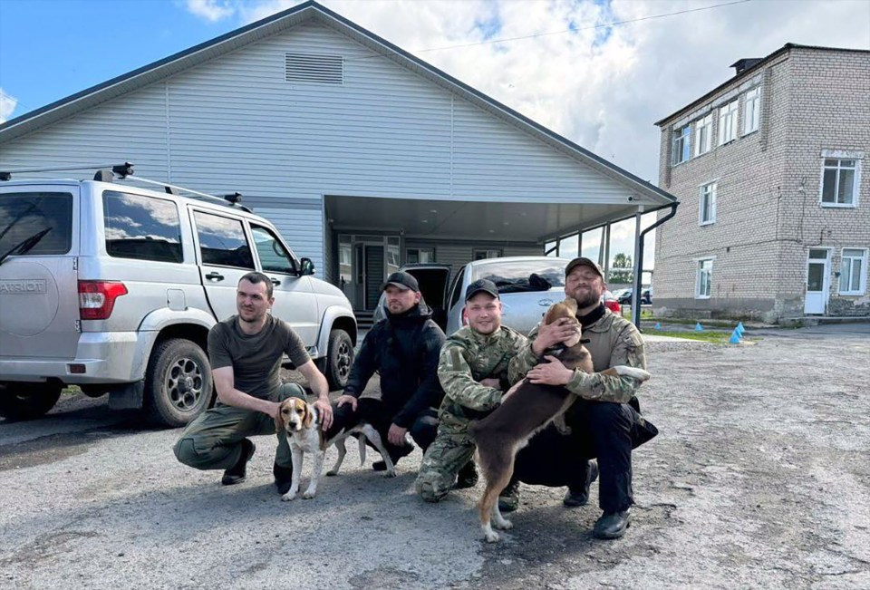 Rescuers who found the sibling pose with the family’s beagles who stayed with the children, warming them at night and scaring away wolves