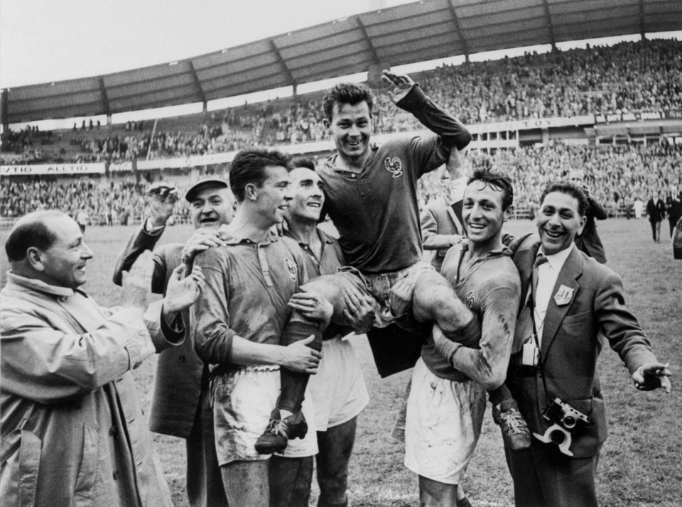 a soccer player is being lifted in the air by his teammates