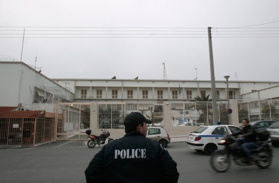 a man in a police uniform stands in front of a building