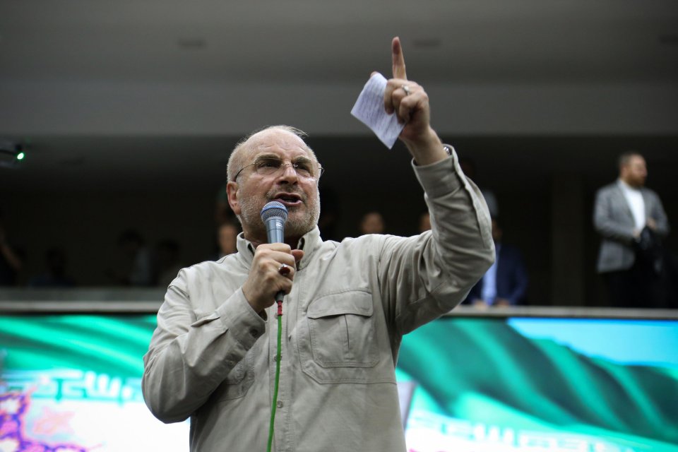 a man speaking into a microphone with his finger pointing up