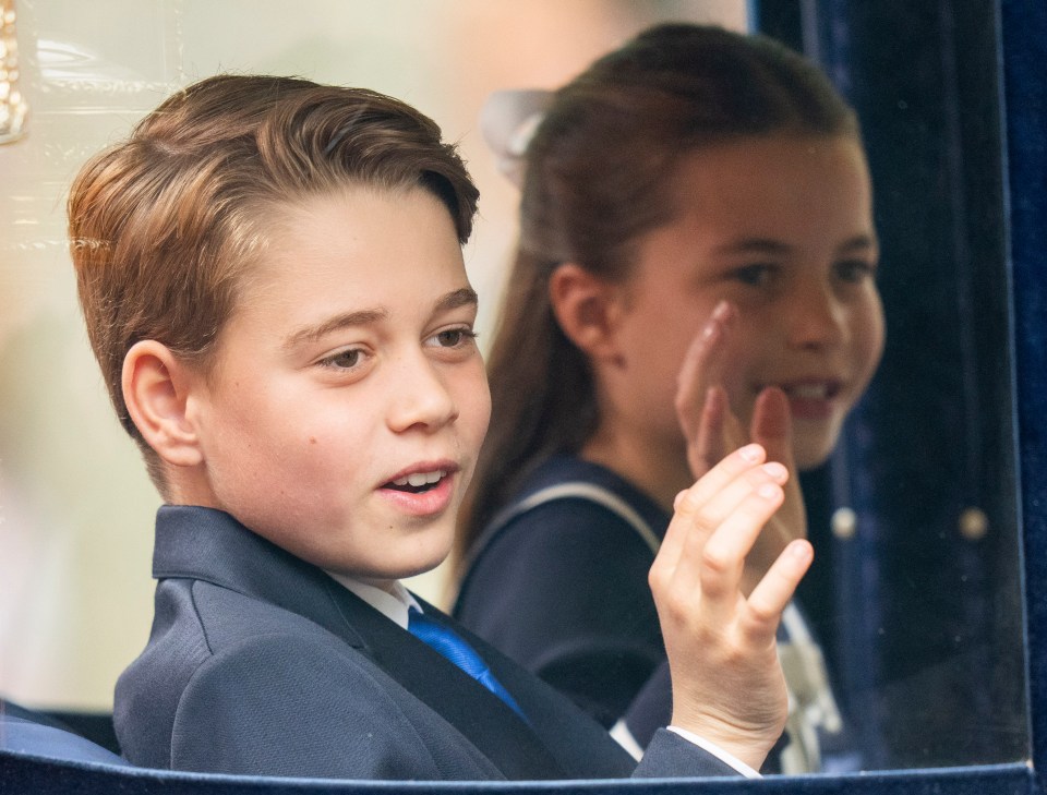 Prince George and Princess Charlotte wave to fans queuing up on the Mall