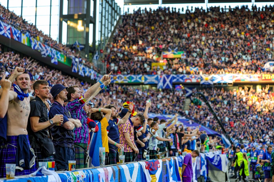 a crowd of people in a stadium with a banner that says ' scotland ' on it