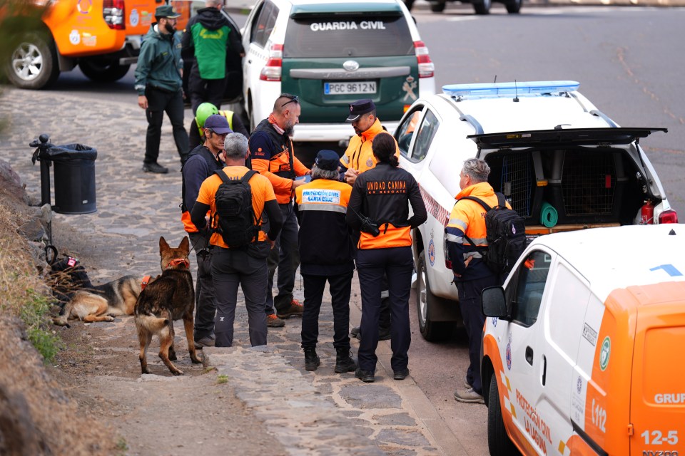 a group of people standing in front of a guardia civil car