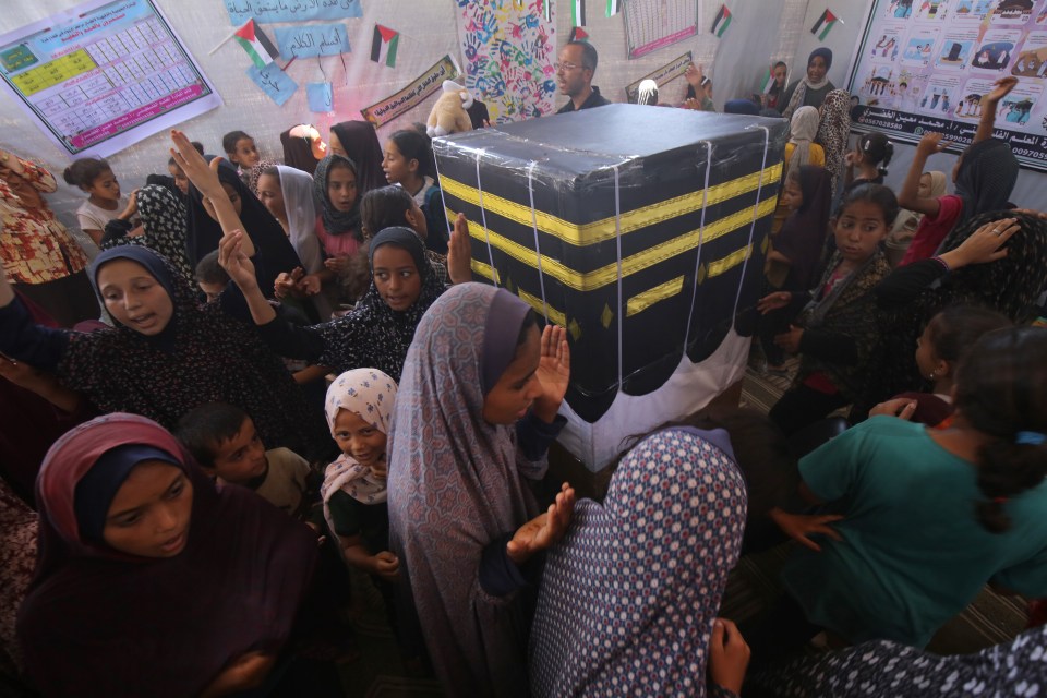 Displaced Palestinian children gather around a makeshift cube representing the holy Kaaba, at Al-Aqsa Martyrs Hospital