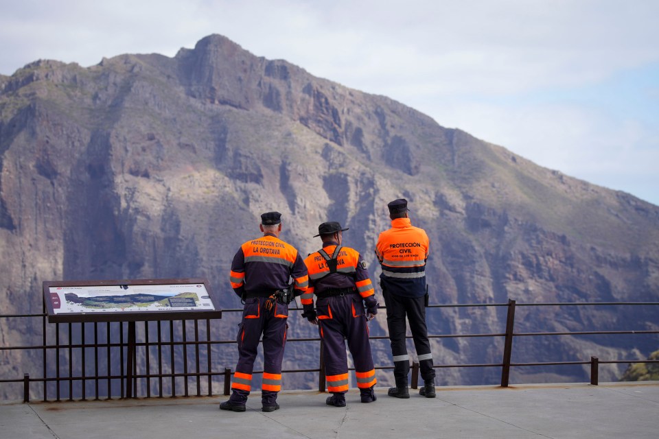 three men are standing in front of a mountain wearing uniforms that say protector civil