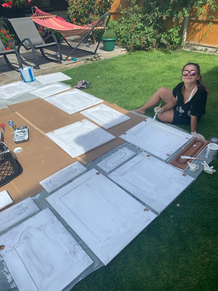 Becky Shipley pictured painting a kitchen cabinet