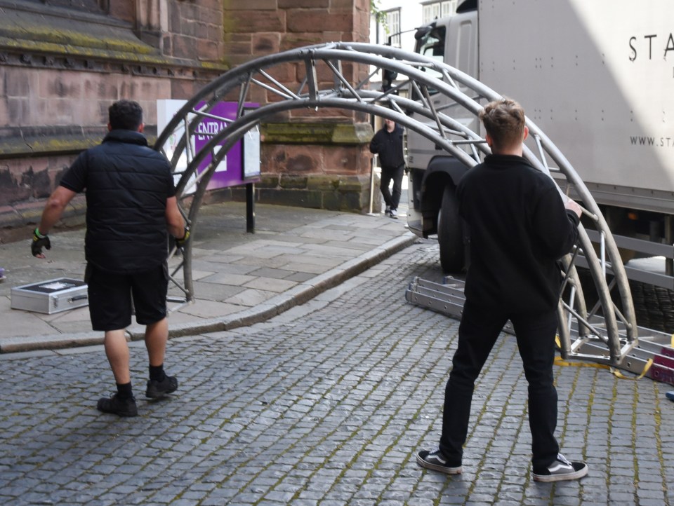 An arch is taken into the church to be mounted with flowers ahead of the wedding