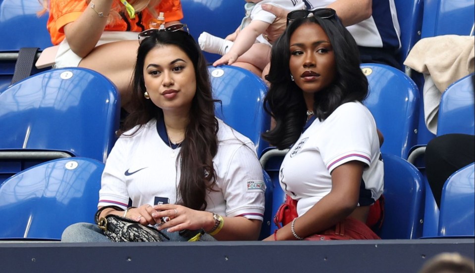 a baby is being held by a woman in a soccer stadium