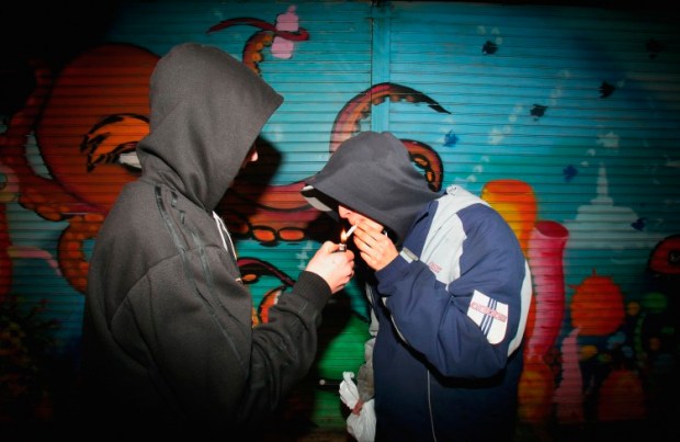 BRISTOL, UNITED KINGDOM - FEBRUARY 1: Young persons in hooded tops share a cigarette outside a shop on the Southmead housing estate, February 1, 2007, Bristol, England. Bristol City Council is one of 40 local authorities in England and Wales to be declared a 'Respect' zone on the basis of indexes such as deprivation, high levels of antisocial behaviour, truancy and school exclusion levels. (Photo by Matt Cardy/Getty Images)