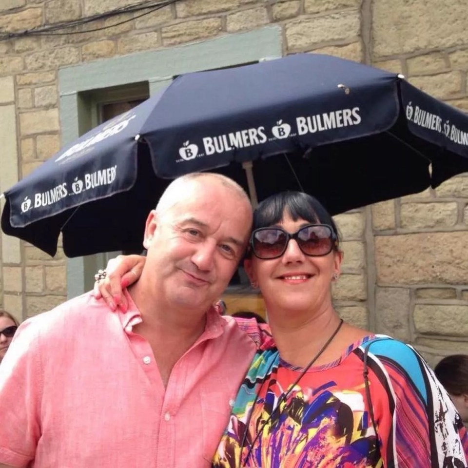 a man and woman standing under a bulmers umbrella