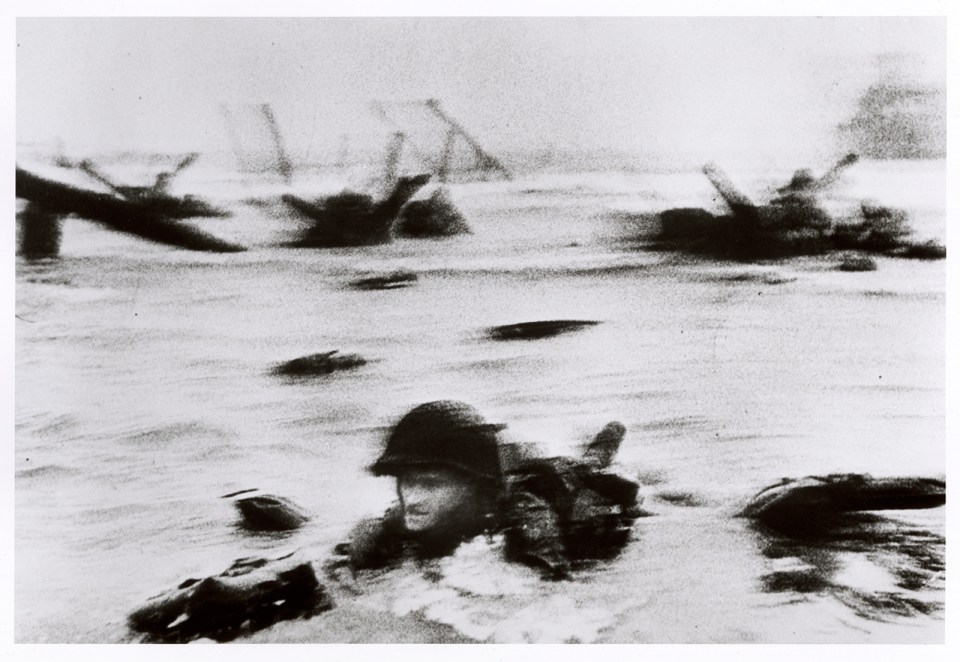 Troops wade through 4ft high water while under fire to land on Omaha Beach in stunning live photo by Robert Capa